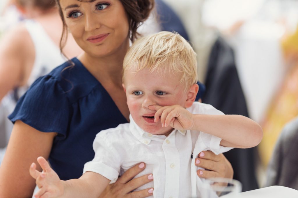 close up of young lad picking his nose on a wedding day